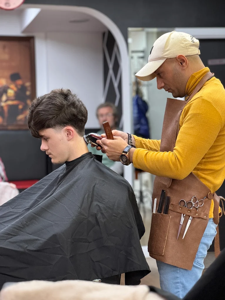 Barber in leather apron giving a skin fade at City Barbers Cork